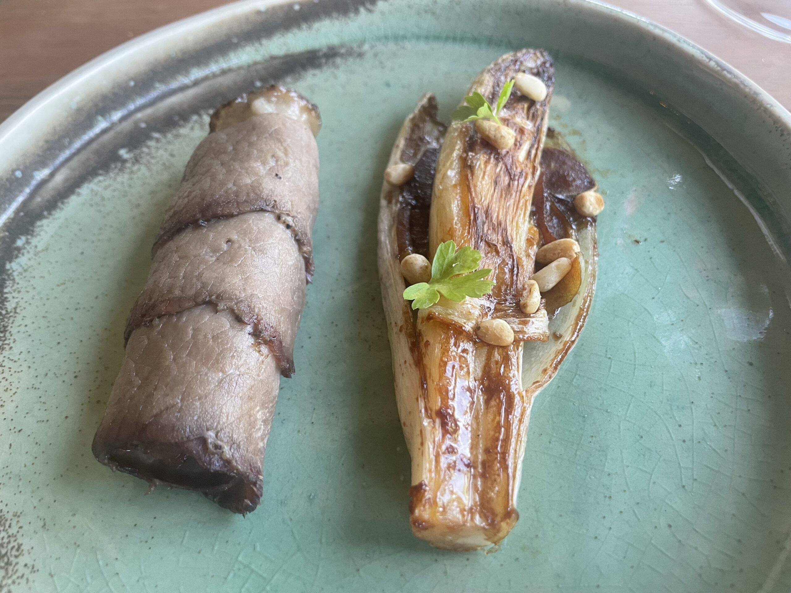  Meso z belgijskim radičem, karameliziranim sokom divjega jabolka in pinjolami.