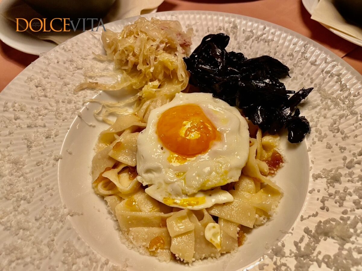 Domači široki rezanci z zaseko, jajcem, črnimi trobentami in kislim zeljem.