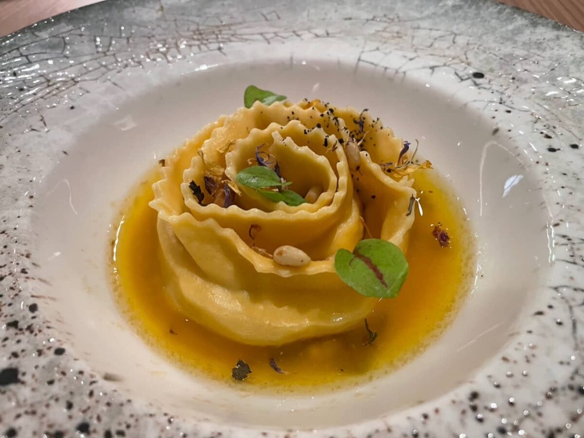 Velik raviol s škampi, maslom in žajbljem.